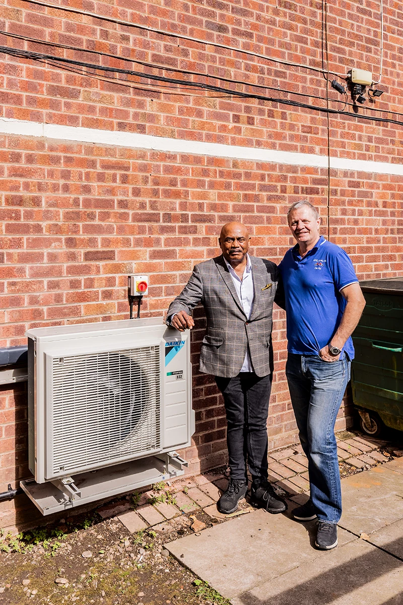Two project representatives beside the installed Daikin outdoor heat pump at the Birmingham apartment development